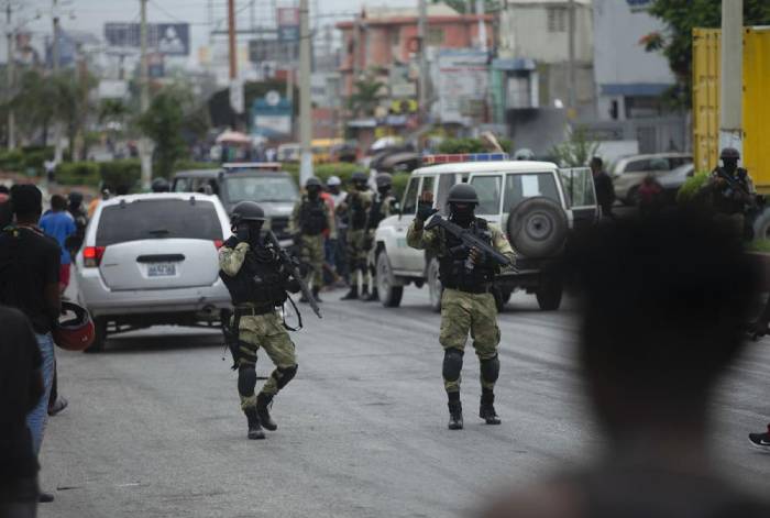 La policía intenta asegurar un área tras una barricada colocada por taxistas que protestan por la escasez de combustible, en Puerto Príncipe, Haití, el jueves 14 de julio de 2022. (Foto AP/Odelyn Joseph)