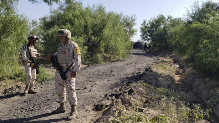 La Guardia Nacional se encuentra a lo largo de la carretera que conduce adonde mineros están atrapados en una mina de carbón colapsada e inundada en Sabinas, en el estado mexicano de Coahuila, el jueves 4 de agosto de 2022. (AP Foto/Elizabeth Monroy)