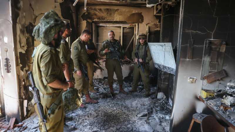 Unos soldados israelíes inspeccionan los daños en un edificio del kibutz Beeri, atacado por militantes palestinos. Foto AFP