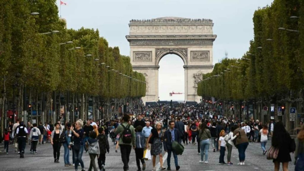 Una multitud camina por la calzada de la avenida de los Campos Elíseos en París que organizará consulta sobre vehículos SUV. Foto: AFP  