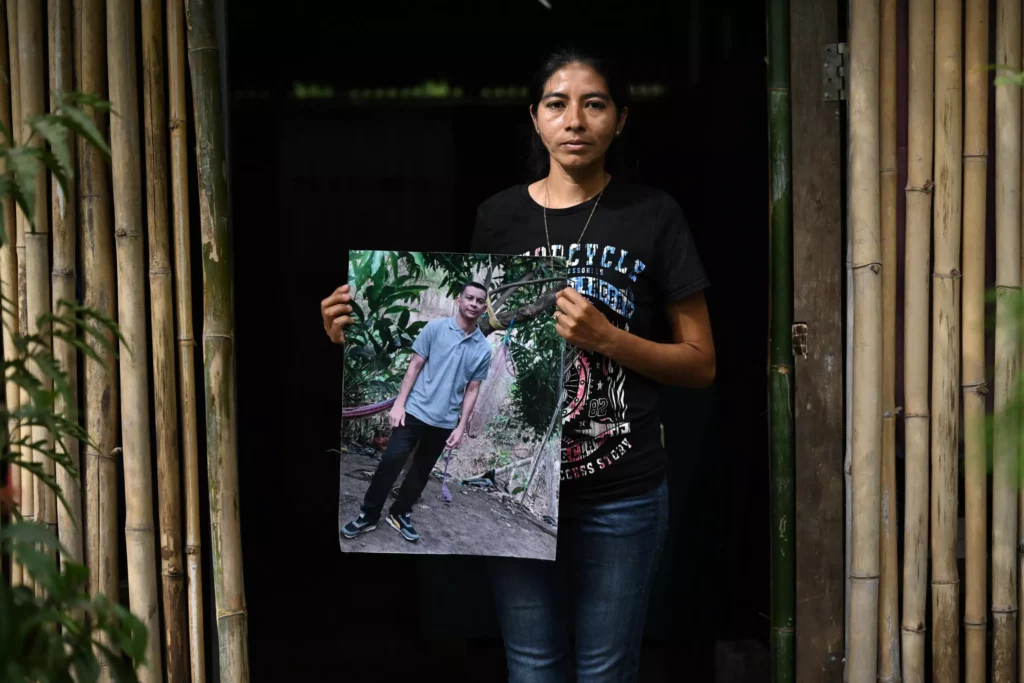 Sandra Hernández posa con una foto de su esposo José Dimas Medrano, quien fue capturado durante el régimen de excepción y murió estando preso, habla durante una entrevista con AFP en El Rosario, El Salvador, el 29 de enero de 2024 