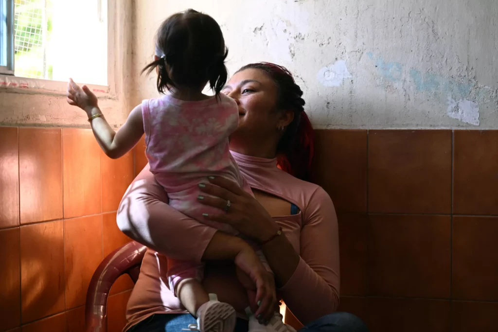 Maricela Méndez, quien estuvo presa tras ser arrestada durante el régimen de excepción, es fotografiada con su hija tras una entrevista con AFP en San Salvador el 29 de enero de 2024 