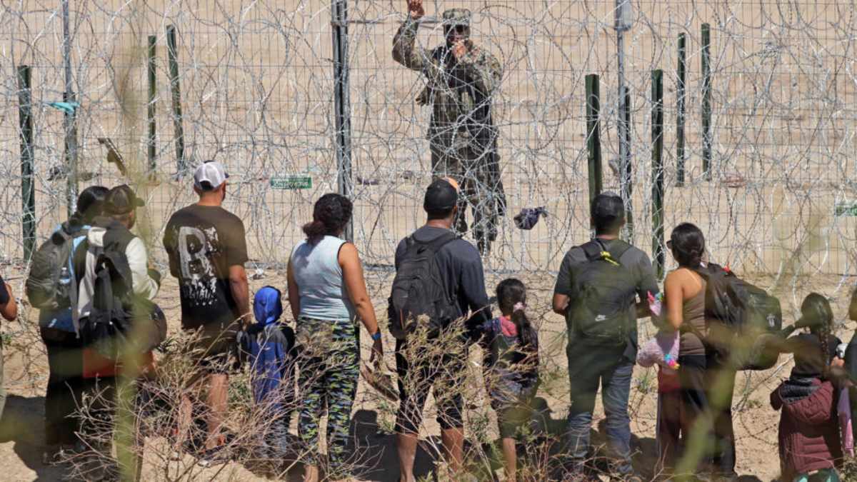 En su intento por cruzar a Estados Unidos, un grupo de migrantes arrancaron el alambre de púas del muro fronterizo en la frontera. Foto: AFP