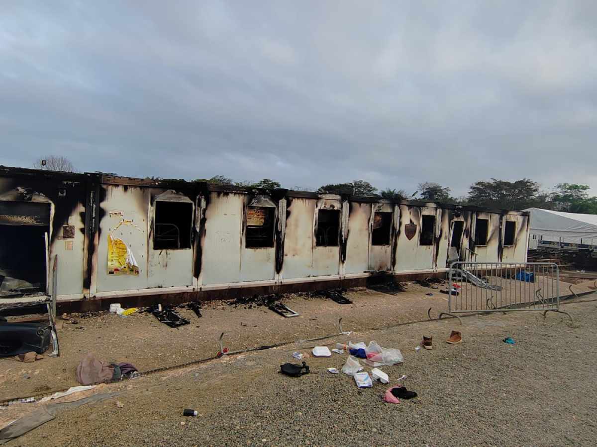 Una decena de construcciones ligeras y algunos vehículos fueron incendiados en medio de una riña en un albergue de migrantes. Foto: AFP